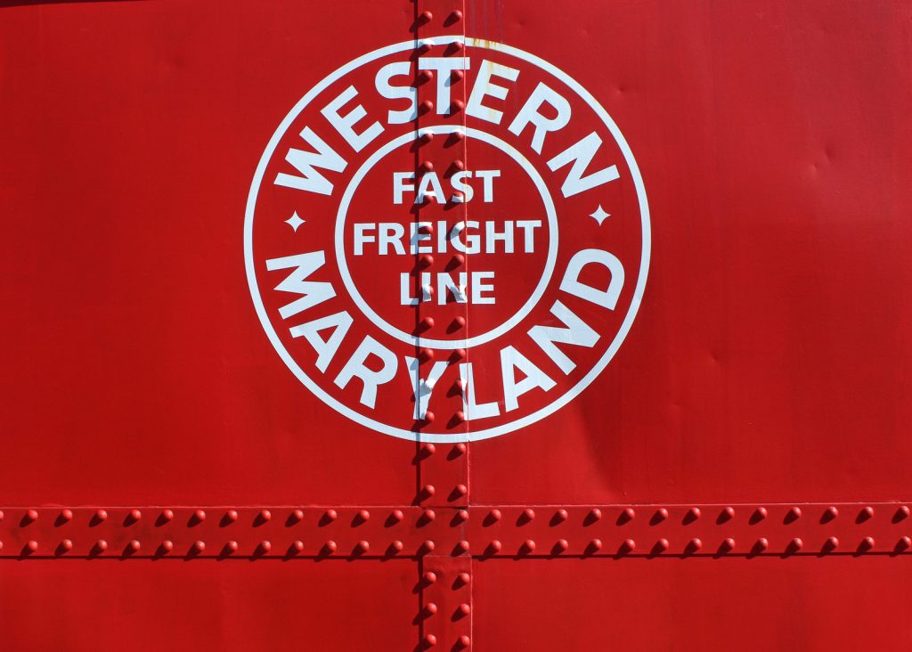 Rolling stock at Hagerstown Roundhouse - a close-up of a white fast freight logo on a red caboose.