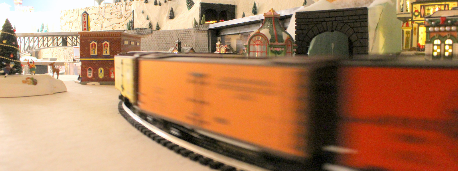 A train speeding by - Christmas at the Roundhouse" model train display.