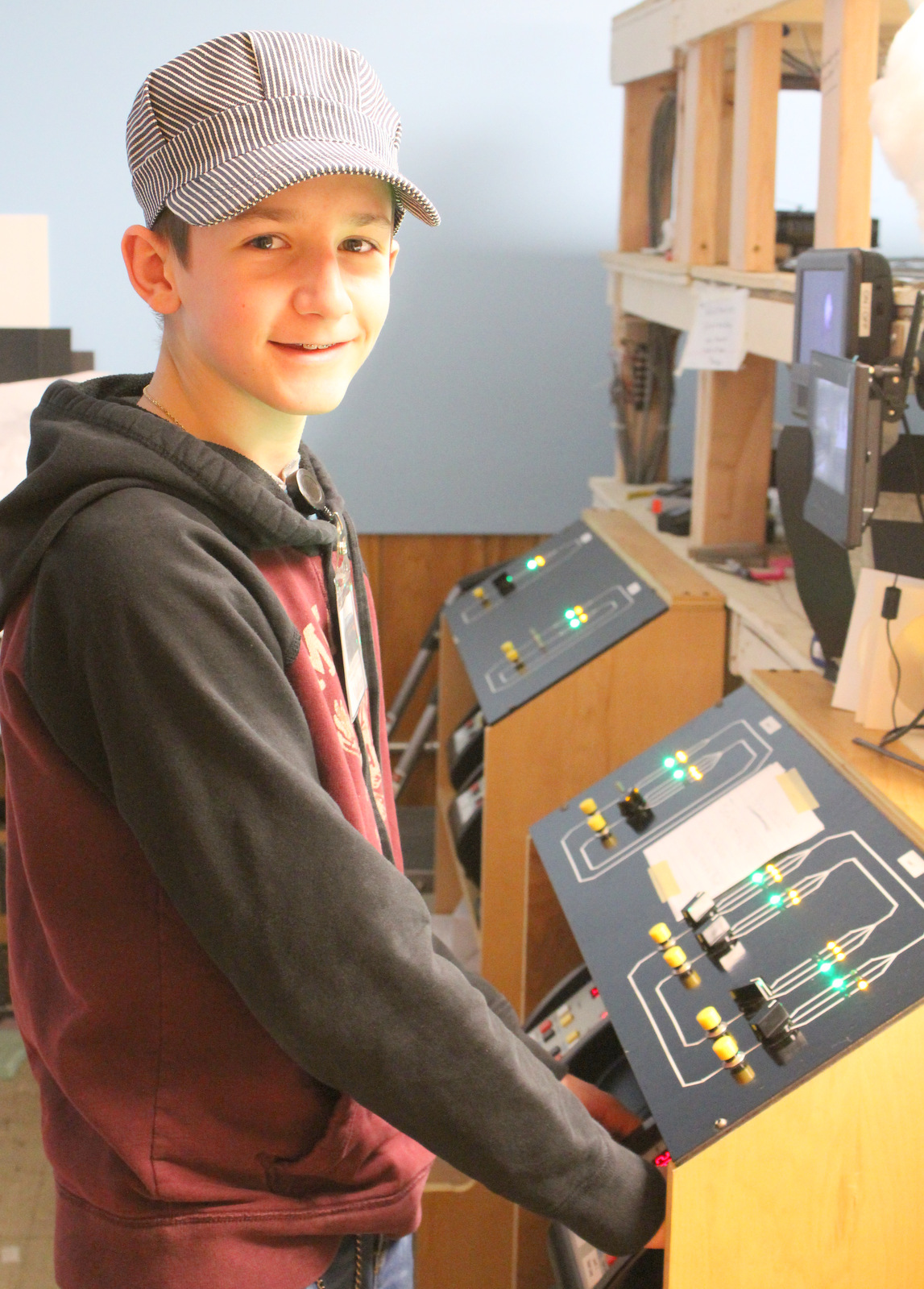 A young model train operator with engineer cap - Christmas at the Roundhouse" model train display.