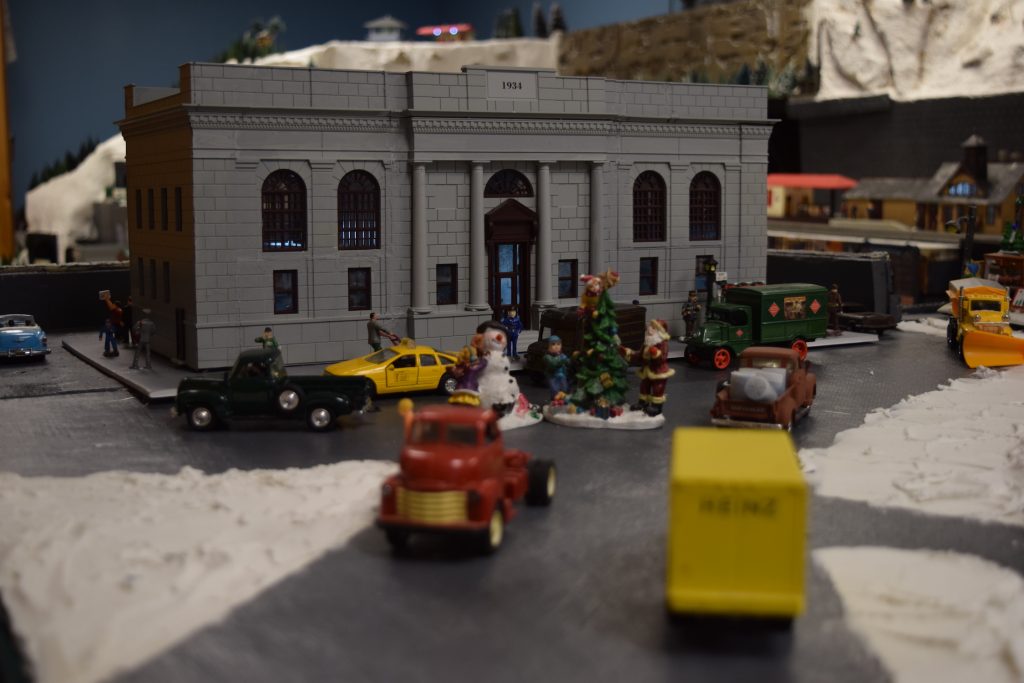 A winter scene in town in front of train station - Christmas at the Roundhouse" model train display.