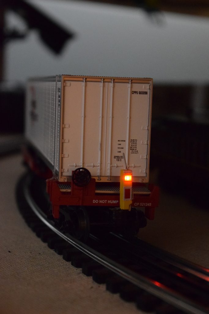 A white boxcar with a taillight - "Christmas at the Roundhouse" model train display.