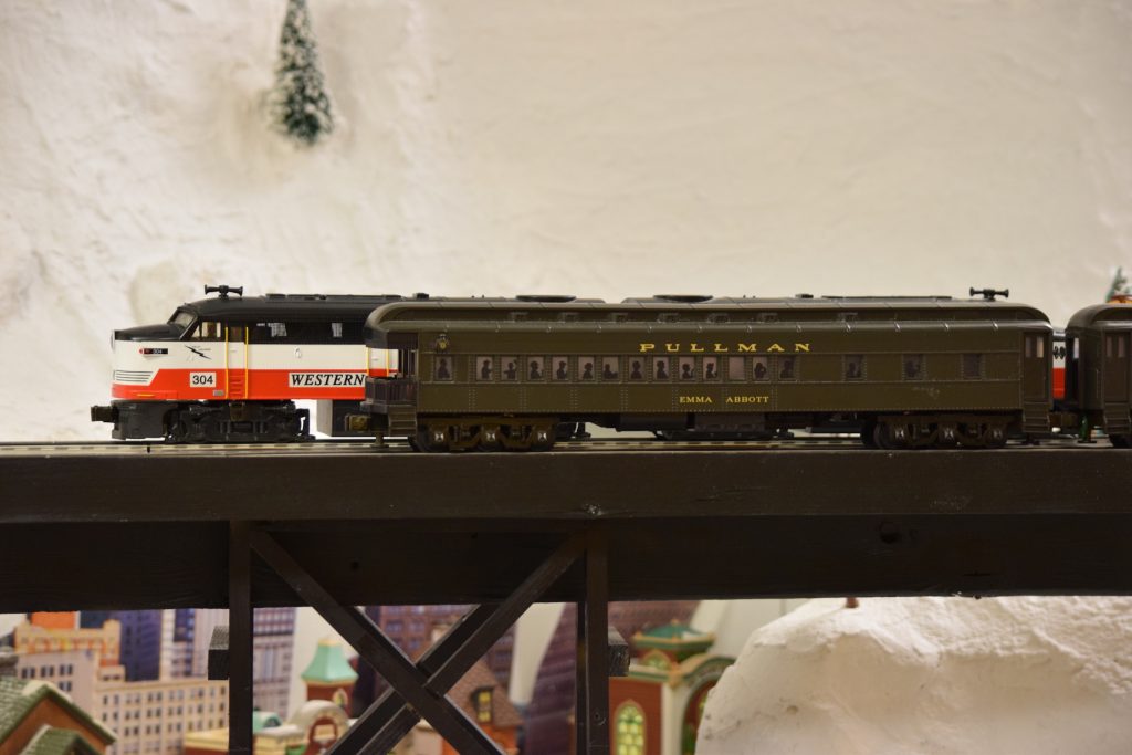 A mountain scene with trains on an overpass - "Christmas at the Roundhouse" model train display.