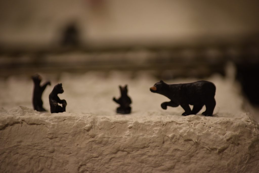 A snowy mountain scene with a bear family - "Christmas at the Roundhouse" model train display.