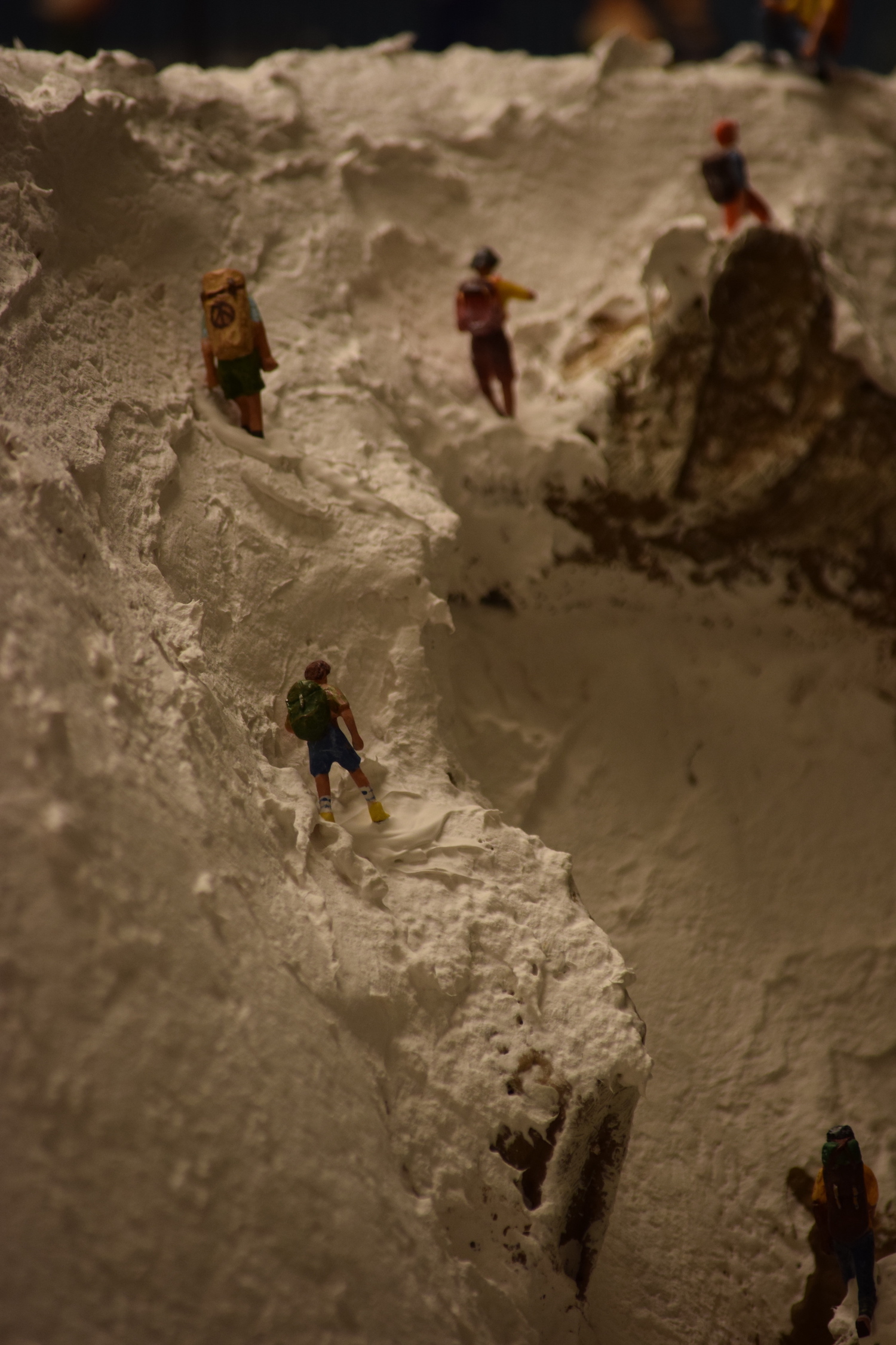 A snowy mountain scene with hikers - "Christmas at the Roundhouse" model train display.