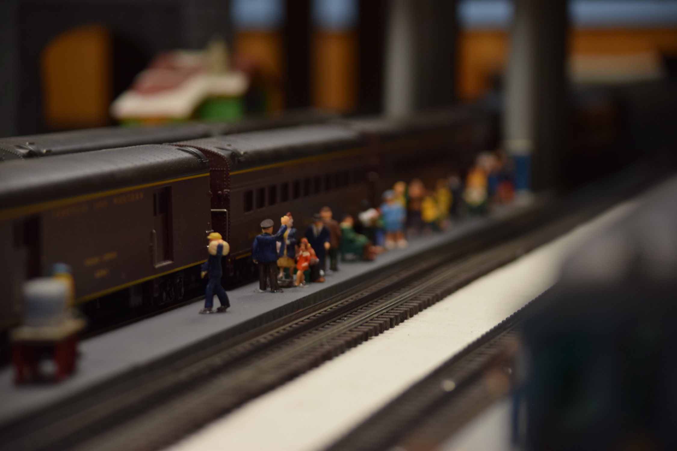 Passengers waiting on a train station platform - "Christmas at the Roundhouse" model train display.