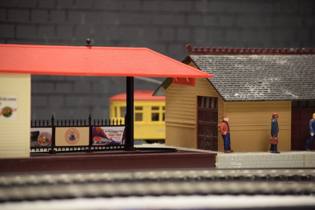 A trolly car pulling into the train station - "Christmas at the Roundhouse" model train display.