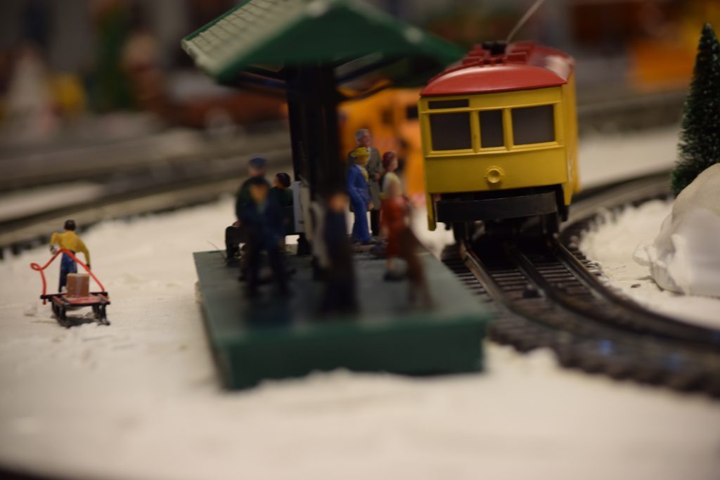 A trolly car pulling into the train station - "Christmas at the Roundhouse" model train display.