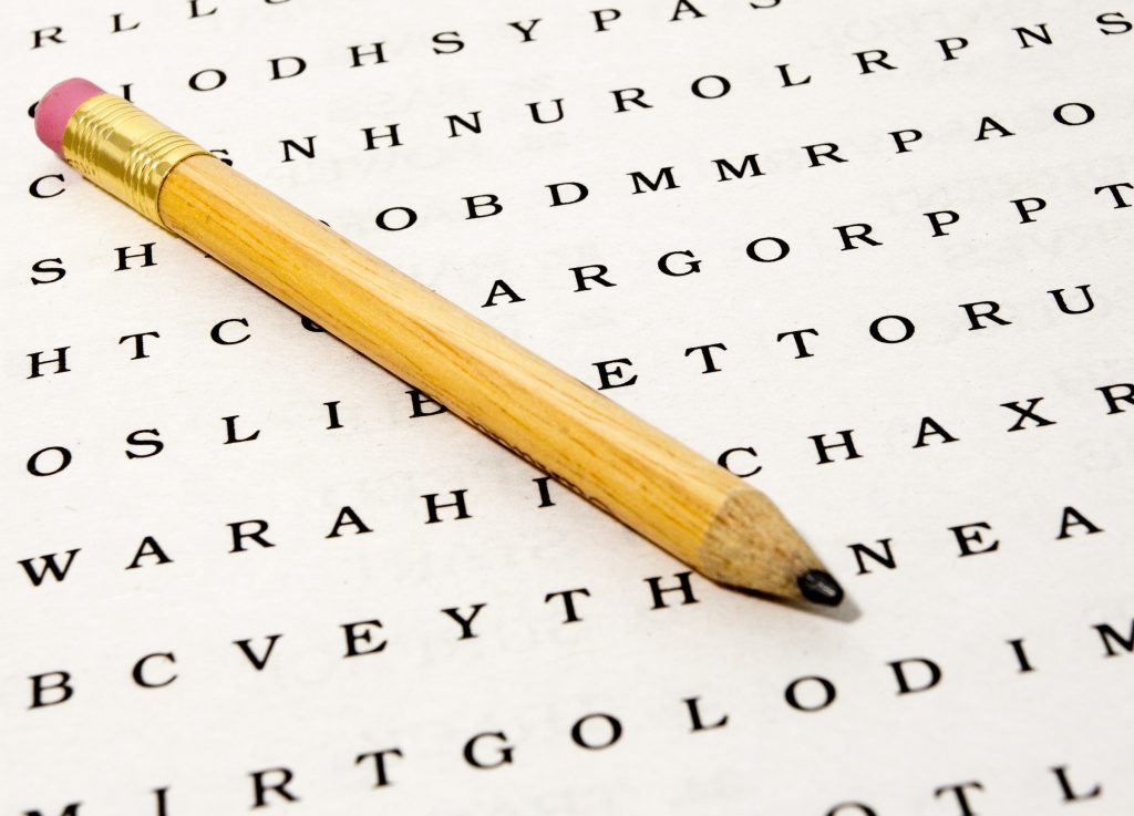 Close up of a a word search puzzle with pencil on white